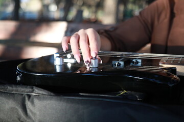 Woman Hands Turn Knobs For Tone Of Electric Bass Musical Instrument