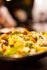 A bowl of fresh caesar salad with bacon, croutons and cheese