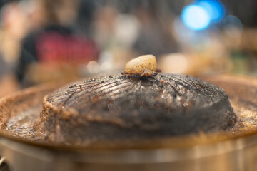 Pork belly cubes burnt and dirty on pot stove for pork grilled after eating finish. Thai style cuisine called Moo Ka Ta