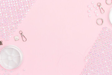 Details, equipment and findings for handcraft beaded bag scattered on a pink background with copy...