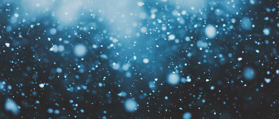Snowflakes fall gracefully against a dark backdrop creating a serene winter atmosphere