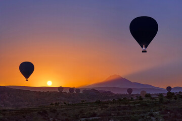 Hot air balloons at the sunrise in Cappadocia with the Mount Erciyes, Turkey