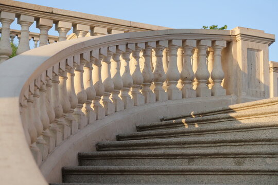 historical architecture of balustrade stairs in park. stone steps and balusters of classic-style staircase in public park. white and pink walls with texture.