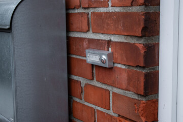 Close up of a simple house doorbell on a bricks wall near the front door