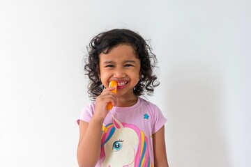 A little Asian girl eating fruit popsicle