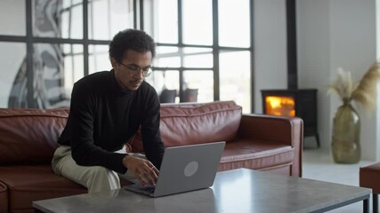 Young man working on laptop in cozy lounge