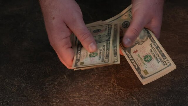 Hands counting US Dollar bills or paying in cash on money background. Concept of investment, success, financial prospects or career advancement. 4k