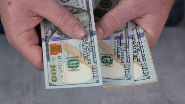 Man is countiong cash money. Dollars. Finance and accounting, calculating return on investment, company budget planning