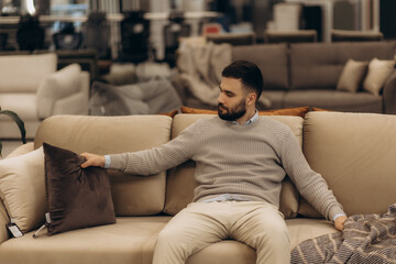 Obraz premium Man in furniture store choosing sofa.