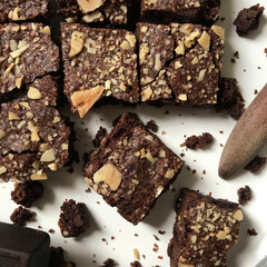 Delicious Chocolate Brownie Squares with Almond Toppings on a White Plate