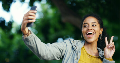 Peace sign, selfie and travel with happy woman at park for commute, holiday or vacation in nature. App, smile and social media with tourism influencer outdoor for adventure or sightseeing photograph