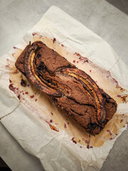 Freshly baked blueberry banana bread resting on parchment, golden crust glistening with caramelized banana slices for Mother's Day Valentines