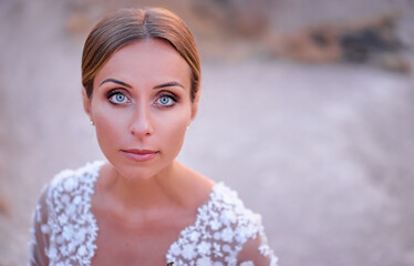 Elegant Bride in a Beautiful Wedding Dress with Delicate Patterns Outdoors..