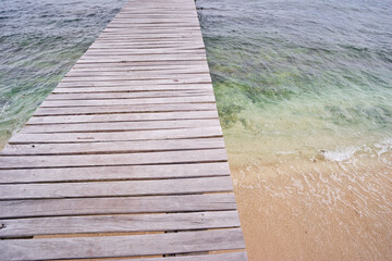 Fototapeta premium Wooden Pier Over Tropical Clear Waters and Sandy Shores