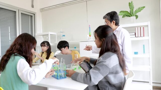 Asian elementary boys and girl school kids students have fun studying sitting in laboratory classroom enjoy mixing liquid substance experiments, education happy learning by doing in private school