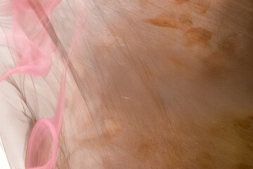 Generated image of pink abstract cloud or smoke. Copper metal background. Copy space. Lighting on the left.	