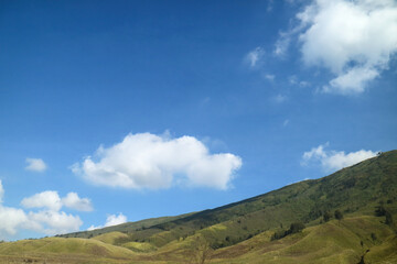 grass savannah with hills and blue sky