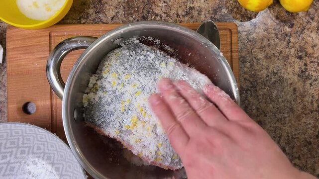The process of salting salmon fish. The pieces of fish sprinkled with salt are placed in a saucepan for salting. Top view.