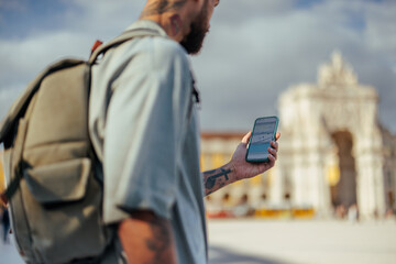 Tourist using navigation app on smart phone in lisbon, portugal