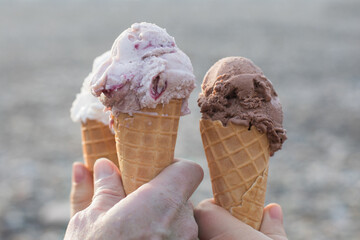 Chocolate, vanilla and berries Ice cream in cone close-up outdoors
