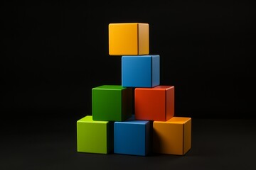Naklejka premium Colorful building blocks stacked creatively on a dark background for playtime or educational activities