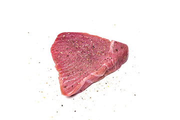 Raw, sliced, salt and coarse pepper seasoned tuna steak meat isolated on white. Top view, close up shot, no people