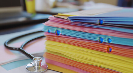Medical documents organized in vibrant colors at a healthcare setting with a stethoscope nearby