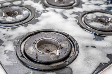 Obraz premium Cleaning a gas stove with kitchen utensils, household concepts, or hygiene and cleaning