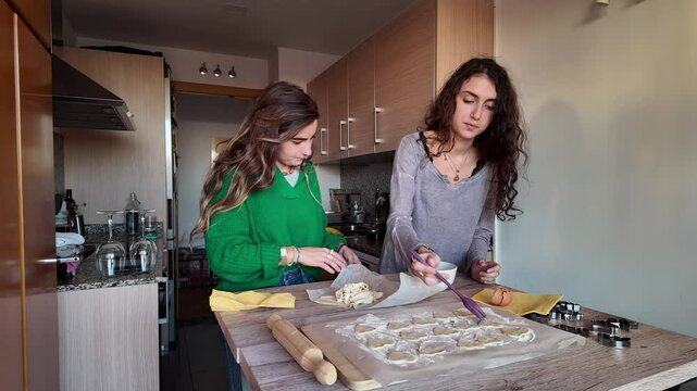 Lesbian couple making valentine's day ravioli together in kitchen
