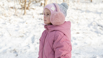 Little girl with having fun on snowy winter day
