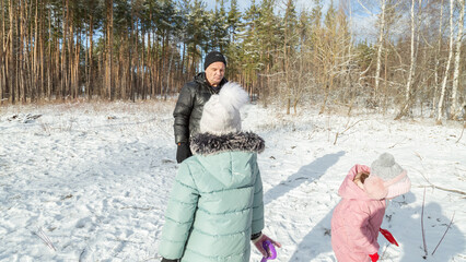Little girls with her grandfather walk in a snowy forest, have fun together