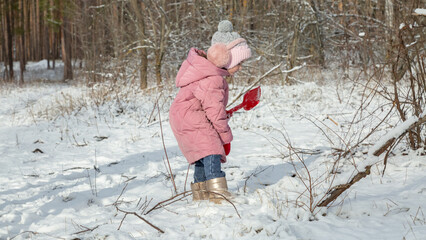 Little girls with her grandfather walk in a snowy forest, have fun together