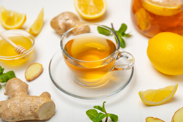 Cup of hot ginger tea with slices of ginger root on wooden background. Warming drink. Alternative medicine. Tea with honey, lemon, ginger and mint. Space for text. Copy space