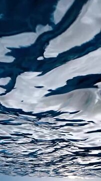 Wave interference patterns in blues and whites under a bright overcast sky. The rhythmic motion creates a hypnotic effect, ideal for dreamlike, meditative, or nature-focused footage.
