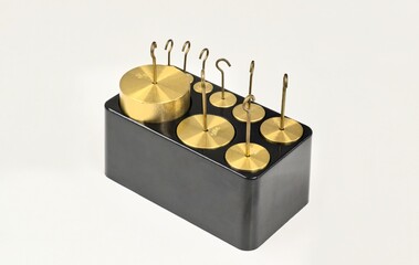 Brass hooked weights scientific laboratory measuring equipment tools.