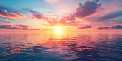 Fototapeta premium A breathtaking sunset reflecting on a tranquil ocean, illuminating the sky.