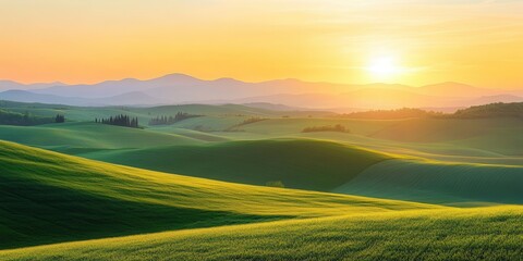 Fototapeta premium A stunning sunset over rolling green hills with distant mountains in the background.