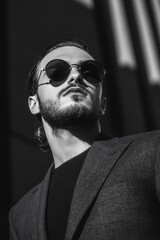 Fototapeta premium Man in Suit and Sunglasses Looking Up