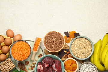 Different products rich in iron on light table, flat lay with space for text. Anemia diet plan