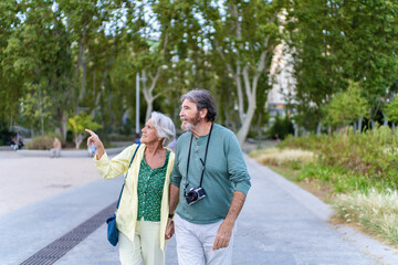 Happy senior couple walking and enjoying sightseeing in city park