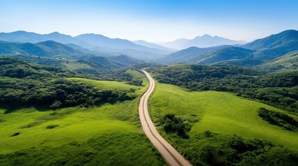 Fototapeta premium Scenic landscape with winding road and rolling hills under clear blue sky in the mountains during daytime