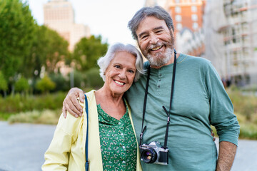 Happy senior couple smiling and embracing in a city park