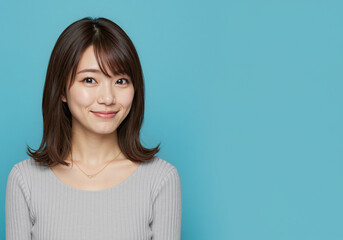 Obraz premium Japanese woman with a beautiful friendly smile looks at the viewer with an endearing and appreciative stare - isolated background with copy space