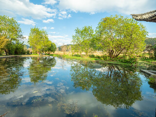 Fototapeta premium Reflections on the tranquil lakeside of Heshun Ancient Town, Tengchong City, Yunnan Province