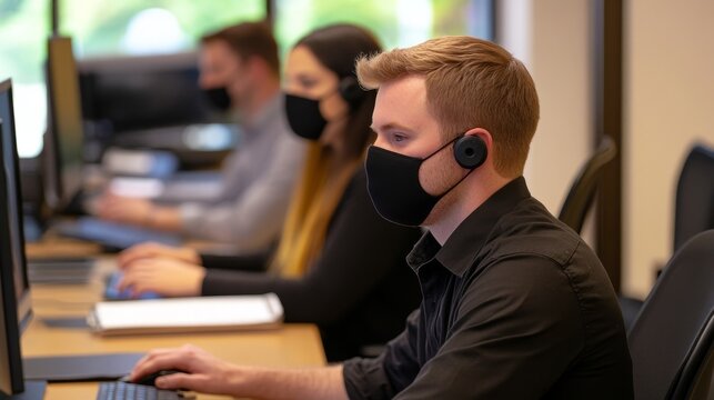 Group of professional wearing mask while working at computer in a modern office environment
