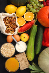Various healthy fruits, vegetables and cereals on dark background. Top view.