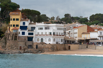 Low tourist season in the Mediterranean village on the Costa Brava sea coast. Colorful residential or holiday houses with a sea view.