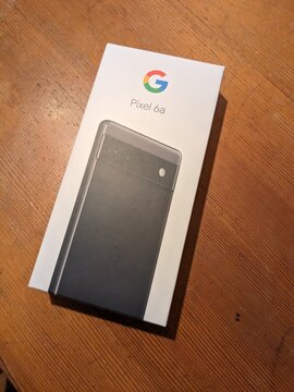 Prague,Czech Republic-January 8 2024: PIXEL 6A smartphone unboxing showing contents of Google Pixel 6a retail box with device, cable and manual on table
