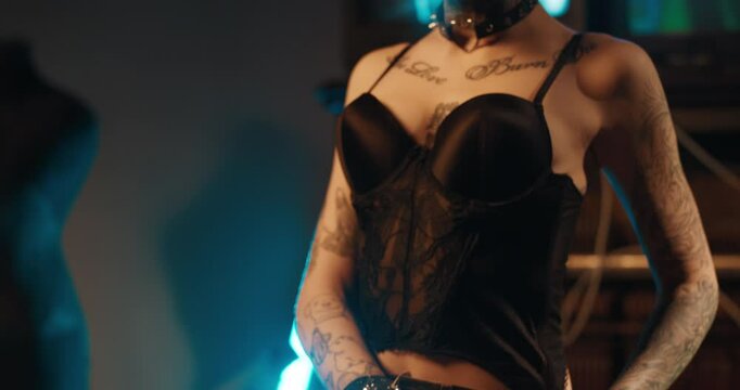 Sensual fashion model woman with tattoos and piercing posing in studio, details. Slender body of attractive lady, alternative style clothing and lifestyle, extravagant appearance, self-expression