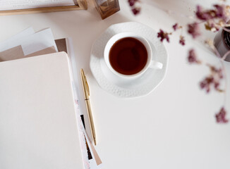 Simple elegant desk background with cup of tea and stationery, neutral beige and pastel tones, white background with copy space